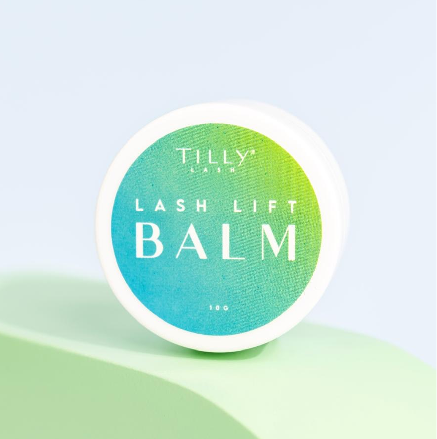 A container of Tilly's Lash Lift Balm placed on a green surface, with a label that includes the product name and the brand logo.
